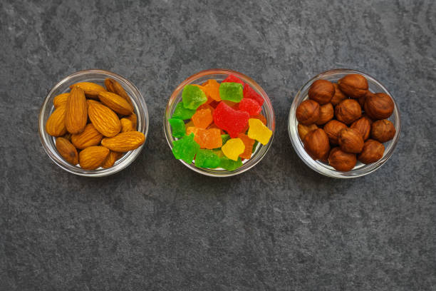 Various nuts and candied fruits on black marble background
