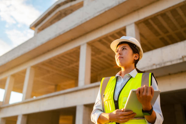 istock Portrait of young female engineer holding digital tablet on construction site 1338088874