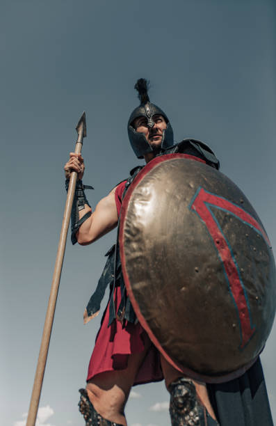istock Ancient Spartan warrior in battle dress stands with shield and spear. 1338088925