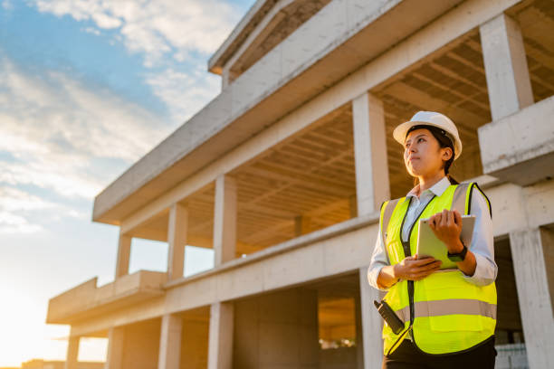Portrait of young female engineer holding digital tablet on construction site
