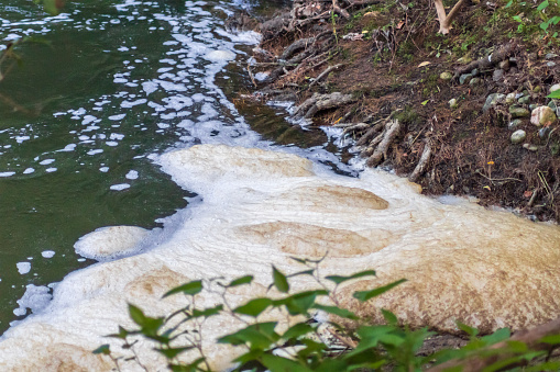 Polluted foam on a river. Concept of environmental issues, as river pollution. Copy space.