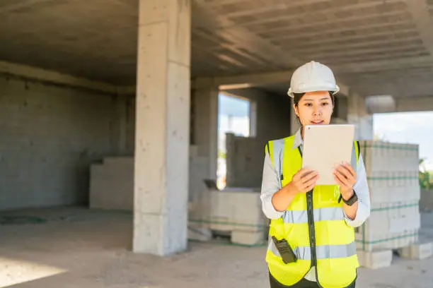 Photo of Young female engineer using digital tablet on construction site
