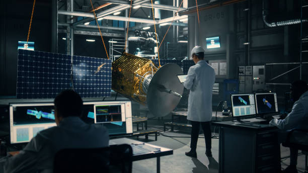 istock Industrial Engineer Working on Artificial Satellite Construction. Aerospace Agency: Scientist in Hard Hat Using Laptop Computer to Develop Spacecraft for Space Exploration and Data Communication. 1338090211