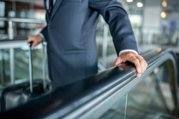istock Male hand touching handrail on escalator 1338092584