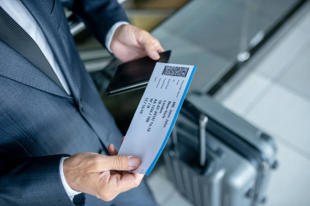 istock Man considering plane ticket at airport 1338092588