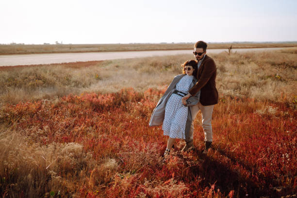 Beautiful young couple walking and hugging outdoors. Autumn.