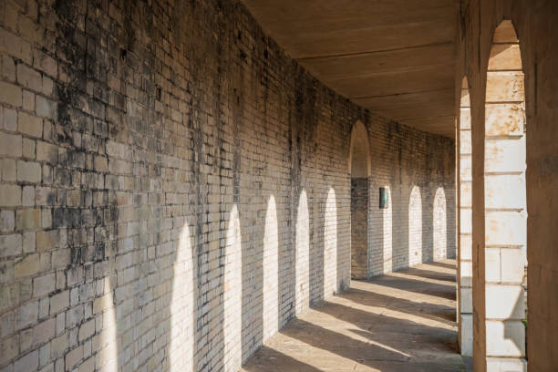 sonnenlicht wirft schatten auf kolonnade auf dem brompton friedhof in london - cast in stone stock-fotos und bilder
