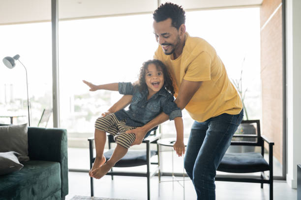 istock Man playing with his son carrying him at home 1338096506