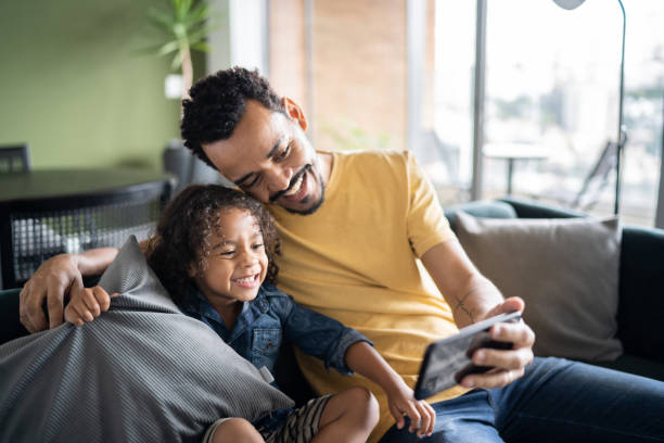 istock Father and son watching something or doing a video call on smart phone at home 1338096519