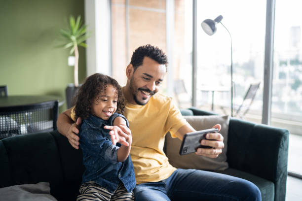 istock Father and son watching something or doing a video call on smart phone at home 1338096558