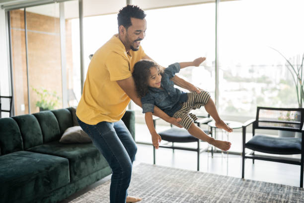 istock Man playing with his son carrying him at home 1338096590