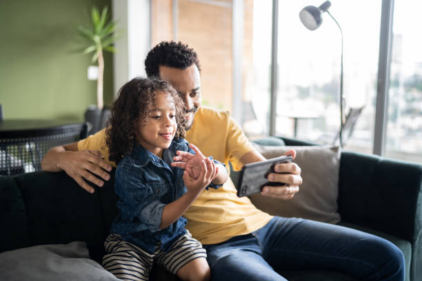 istock Father and son watching something or doing a video call on smart phone at home 1338096605