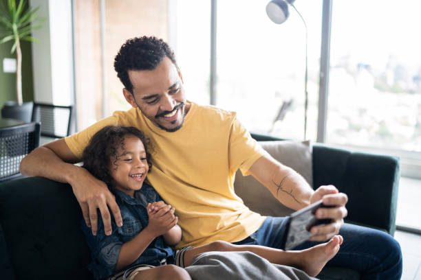 istock Father and son watching something or doing a video call on smart phone at home 1338096617