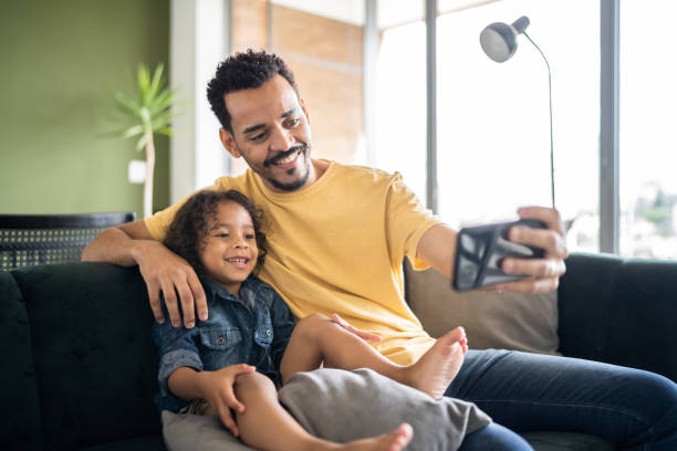 istock Father and son watching something or doing a video call on smart phone at home 1338096732