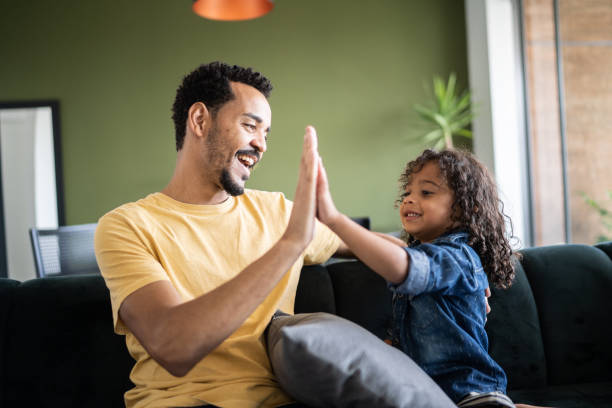 istock Father and son playing and doing a high five at home 1338096763