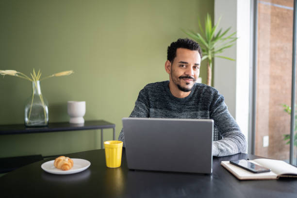 istock Portrait of a man using laptop at home 1338097311