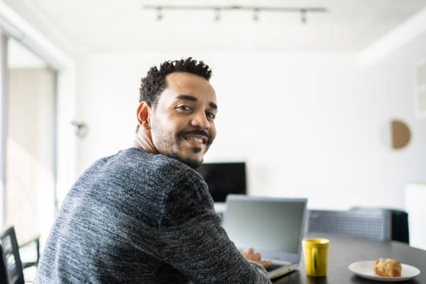 istock Portrait of a man using laptop at home 1338098003