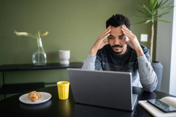 istock Worried or tired man working using laptop at home 1338098036