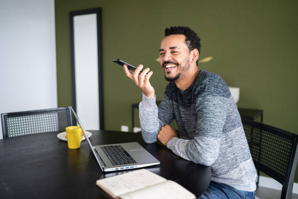 istock Man sending audio message on the phone at home 1338098125