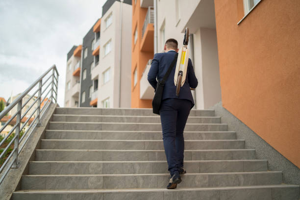 istock Man holding scooter in his hands while standing outdoors in the city 1338098328