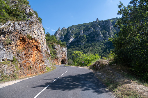 Road in the Gorges du Tarn passing under a rock formation