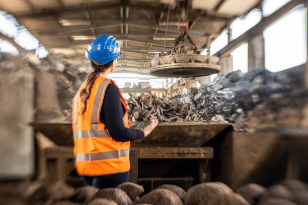 rear view of female engineer inspecting scrap in scrap yard - magnetic storage imagens e fotografias de stock