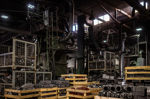 Central perspective of ruined factory hall with debris.