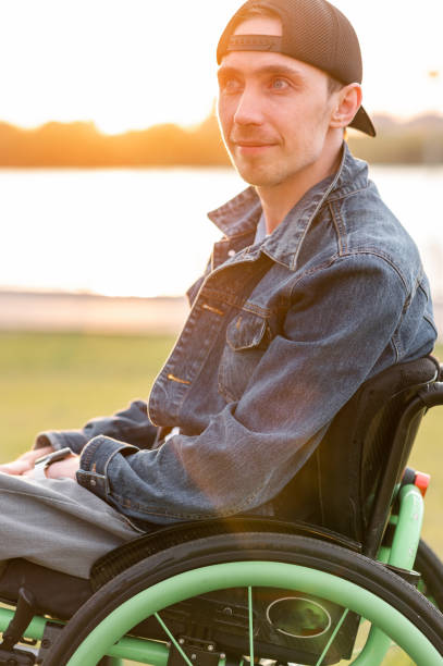 istock young disabled man in wheelchair walking park 1338104276