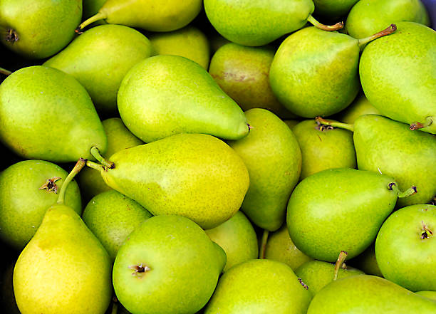 Pile of ripe fresh green pears Green pears at a famers market in France pear stock pictures, royalty-free photos & images