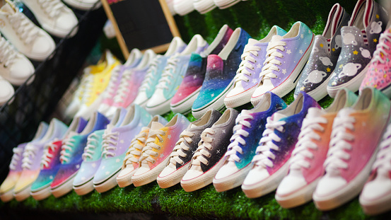 Many colorful sneakers on night market Esplanade in Bangkok at market stall