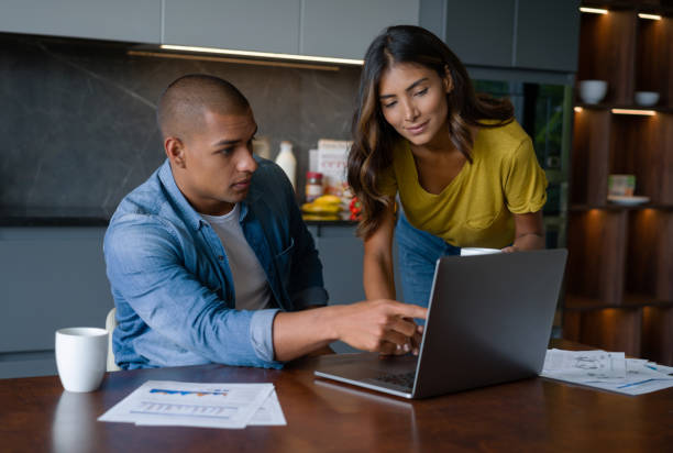 istock Couple paying bills online from home on a laptop computer 1338106272