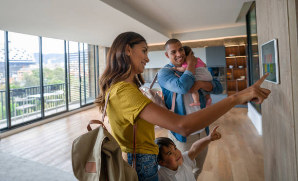 familia feliz saliendo de la casa cerrando la puerta con llave utilizando un sistema de seguridad automatizado - sistema de seguridad fotografías e imágenes de stock