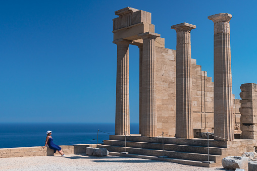 Woman admiring Lindos acropolis on Rhodes island - Greece