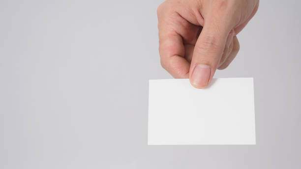 istock Close up of hand holding empty small card on white background. 1338108798