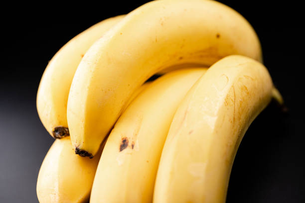 istock Bunch of bananas on black background 1338108815