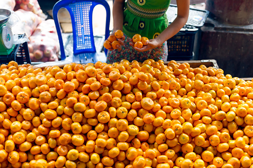 Myanmar. Yangon. Bogyoke Market Aung San, still known by its colonial name, Scott Market, is a great bazaar and market in the city center. Fruits vendor tengerine
