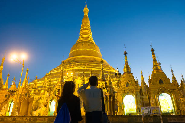 Myanmar. Yangon. Couple at Shwedagon Pagoda Myanmar. Yangon. Couple at Shwedagon Pagoda Buddhist holy place shwedagon pagoda photos stock pictures, royalty-free photos & images