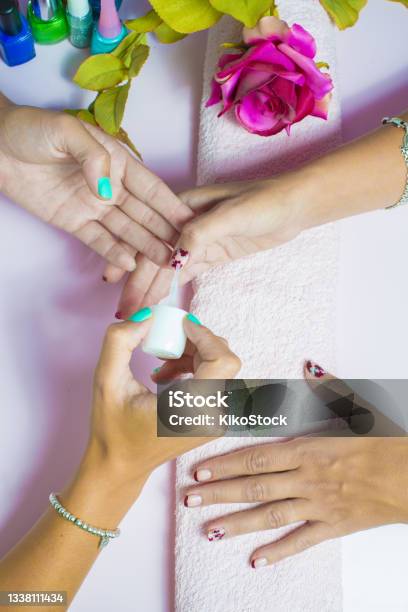 Woman Getting A Manicure And Nail Painting In The Foreground Stock Photo - Download Image Now
