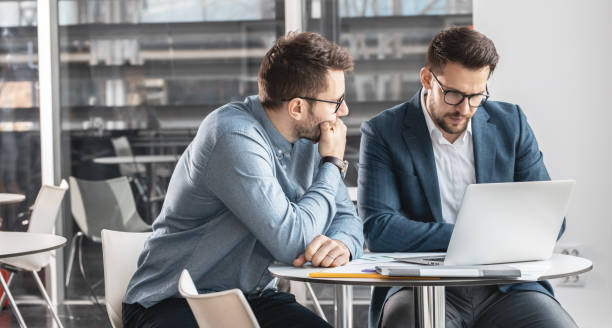 istock Two office workers discuss about new company project. 1338114297