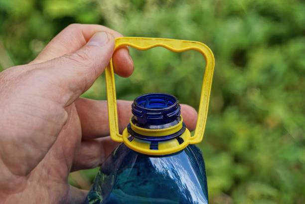 istock hand holds a blue plastic bottle by the yellow handle 1338114910