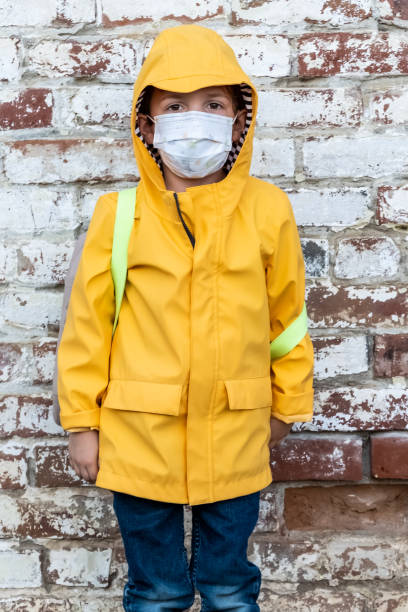 istock Serious annoyed schoolboy looking at the camera using a protective face mask 1338115006