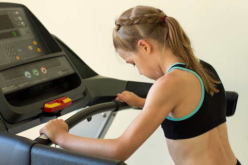 girl in training gym on treadmill, sport activity