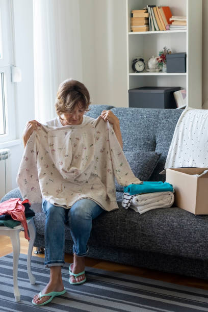 istock Senior woman preparing and packing donations at home 1338117343