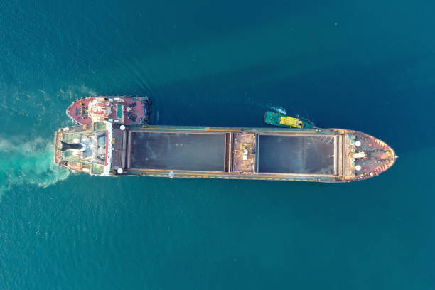 istock A tug pulls a cargo ship in the port. View from above. Shooting from a drone. 1338117400