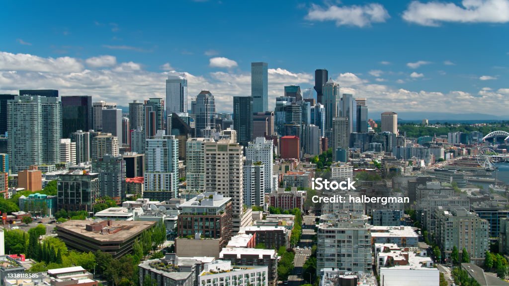 Aerial View Over Belltown Towards Seattle Central Business District Aerial shot of Seattle, Washington on a sunny day in summer from over Lower Queen Anne, also referred to as Uptown, looking south along the Downtown waterfront. Seattle Stock Photo