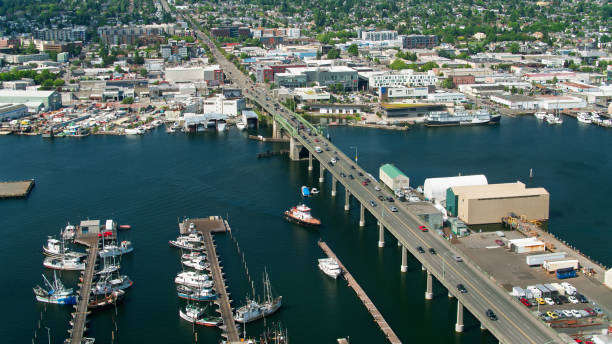 Drone Shot of 15th Avenue Heading Over Canal Into Ballard, Seattle Aerial shot of Seattle, Washington on a sunny day in summer, looking down on the Lake Washington Ship Canal between North Queen Anne and Ballard. ballard-seattle stock pictures, royalty-free photos & images
