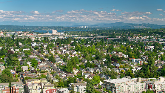 Aerial shot of Seattle, Washington on a sunny day in summer, looking east across residential streets in the Wallingford neighborhood towards Lake Washington, with the Bellevue skyline in the distance.