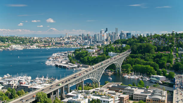 Drone Shot of Seattle with Mt Rainier in Distance Aerial shot of Seattle, Washington on a sunny day in summer, looking along the Aurora Bridge from the Fremont bank of Lake Union towards East Queen Anne and Eastlake, with the downtown skyline in the distance and, much further away, the snowcap of Mount Rainier. washington state photos stock pictures, royalty-free photos & images