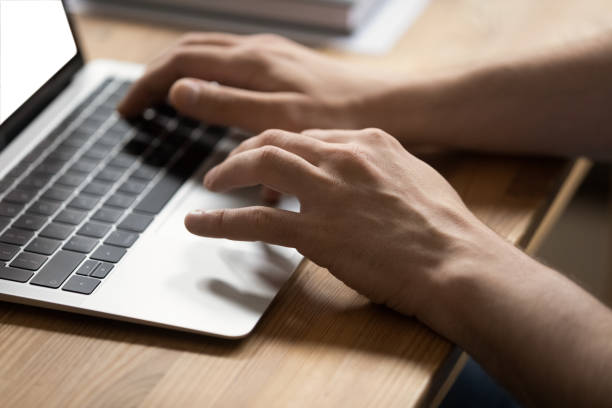 istock Closeup man hands typing on modern laptop at office desk 1338121090