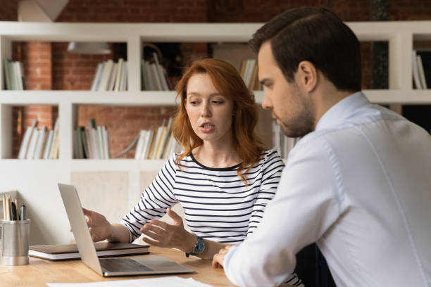Sales manager showing to client online presentation on laptop